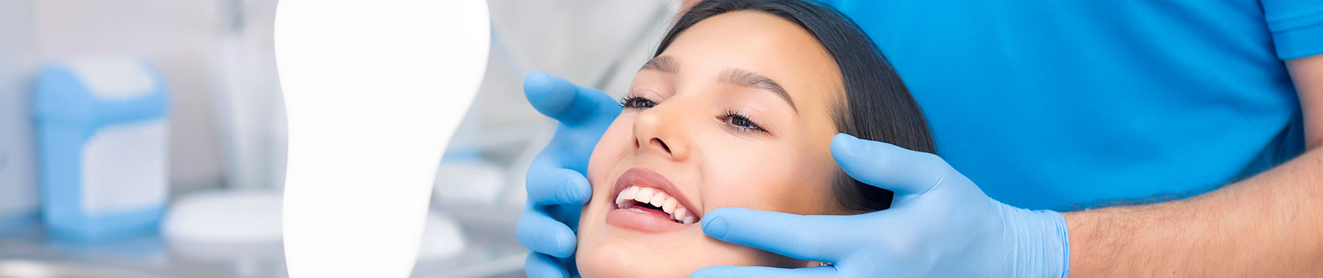 The image shows a group of people, possibly professionals given their attire and the setting that appears to be an office or professional environment. They are gathered around a table with a laptop on it, engaged in what seems to be a discussion or meeting.
